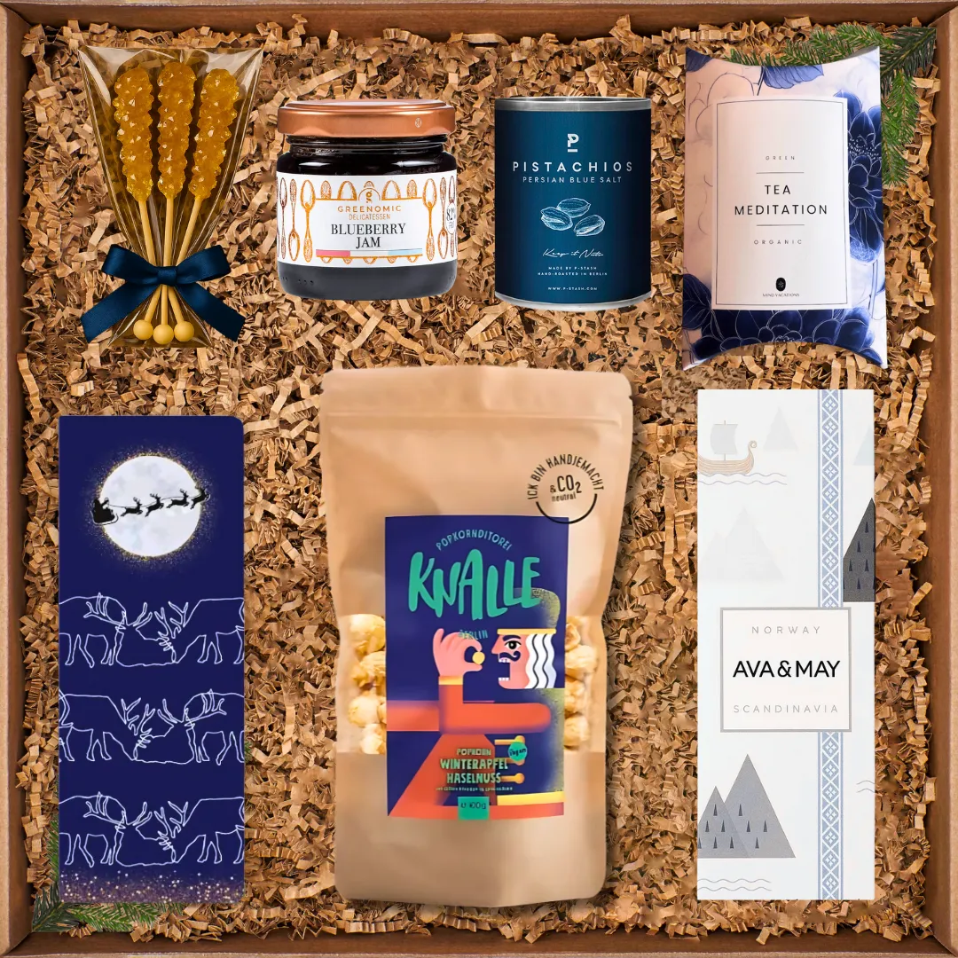 Geschenkbox mit Fruchtbonbon, Heidelbeer-Marmelade, Pistazien, grünem Tee, Popcorn und Duftkerze.
