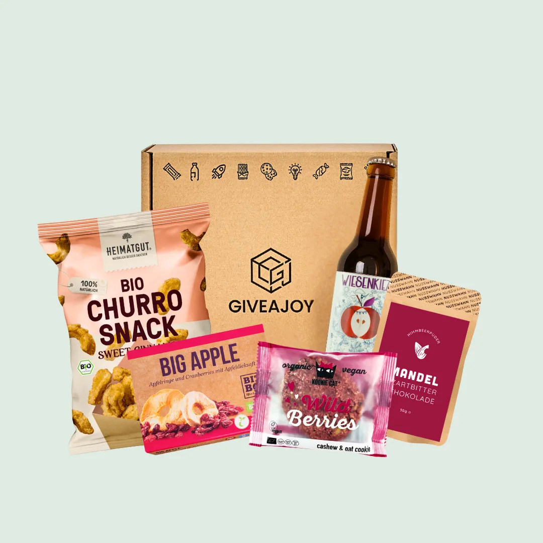 Geschenkbox mit Bio-Churro-Snack, Big Apple Fruchtmix, Wild Berries Cookie, Mandel Schokolade und Flasche Apfelsaft.