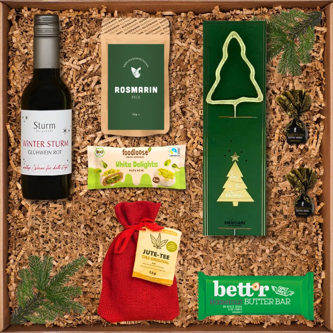 Geschenkbox mit Rotwein, Rosmarin-Mix, Süßigkeiten, Tee, Schokoladenriegel und Kerzenhalter in Tannenbaumform.
